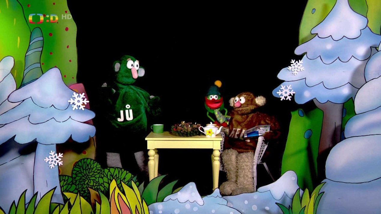 Jůheláci a Muf zapalují první svíčku na adventním věnci.