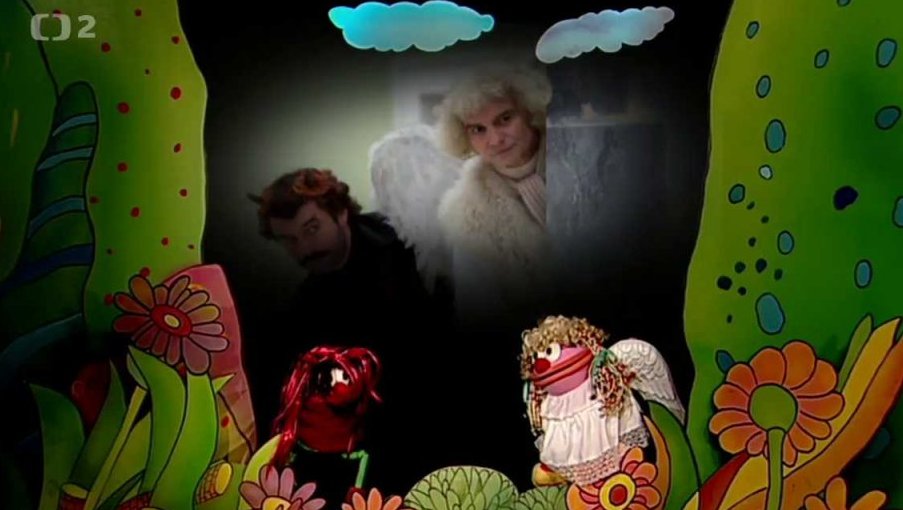 Muf a Fámula, v přestrojení za anděla a čerta, se hádají, jestli je ve filmu Anděl Páně dvojka lepší Petronel nebo Uriáš.